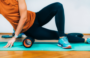 A person using a massage roller for muscle recovery, showcasing Wellfitsource's professional massage & therapy equipment including fascia guns, deep-tissue balls, and therapy tools.