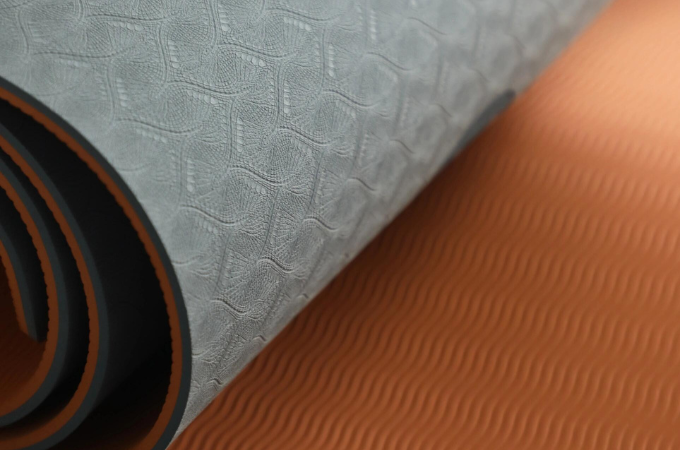 Close-up of a high-quality TPE yoga mat with a dual-layer non-slip surface, featuring a textured design for enhanced grip and cushioning.