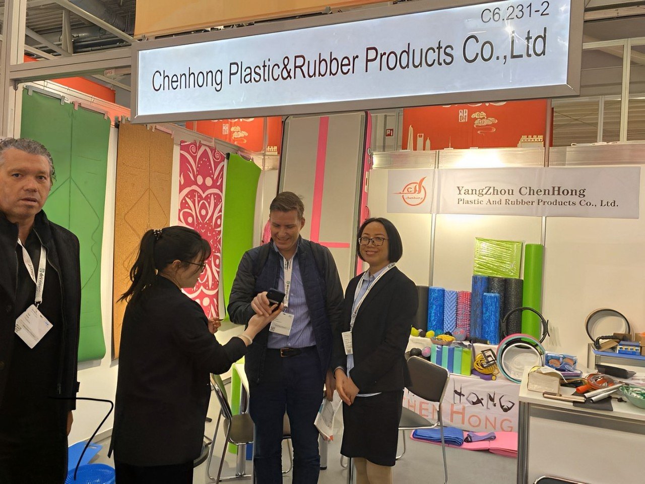 Wellfitsource representatives at an international trade show, networking with global partners and showcasing premium yoga mats.