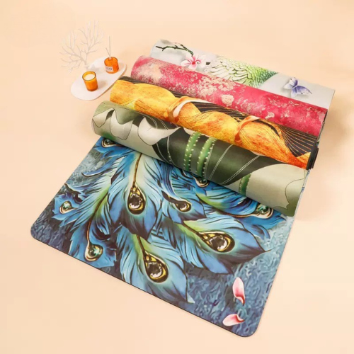 Colorful suede yoga mats rolled and unrolled on a flat surface, featuring vivid custom prints and soft textures.