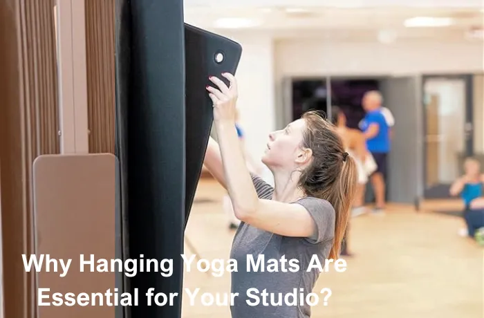 Woman hanging yoga mat on wall hook in a fitness studio