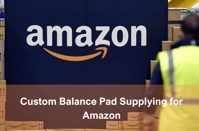 Worker standing in front of Amazon logo wall with stacked shipping boxes