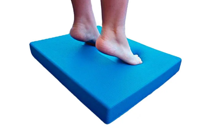 Bare feet standing on a blue 6 cm thick TPE balance pad