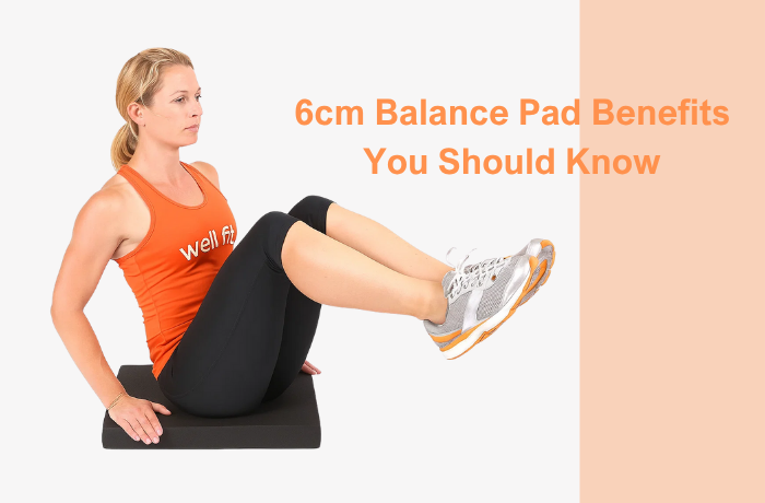 Woman seated on a 6 cm balance pad performing a core stability exercise