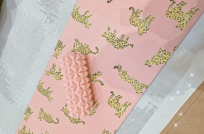 Pink leopard yoga mat with massage roller on top