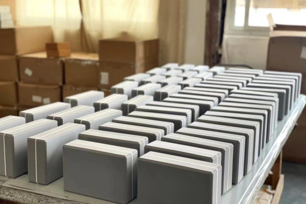 Rows of grey and white yoga blocks lined up on a factory workbench for quality check