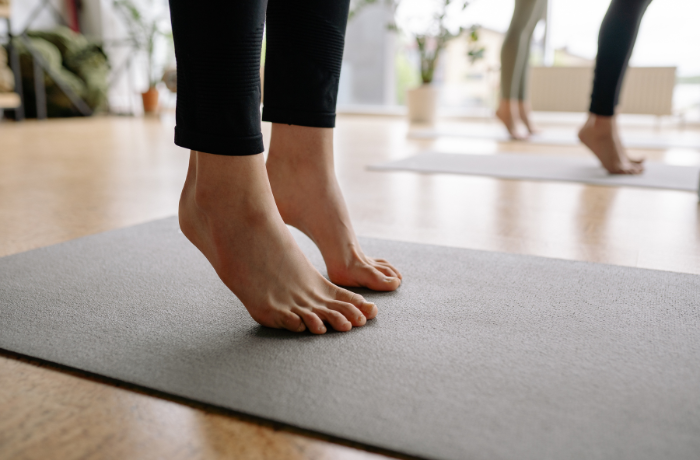 Close-up of a person's feet practicing yoga barefoot on a yoga mat