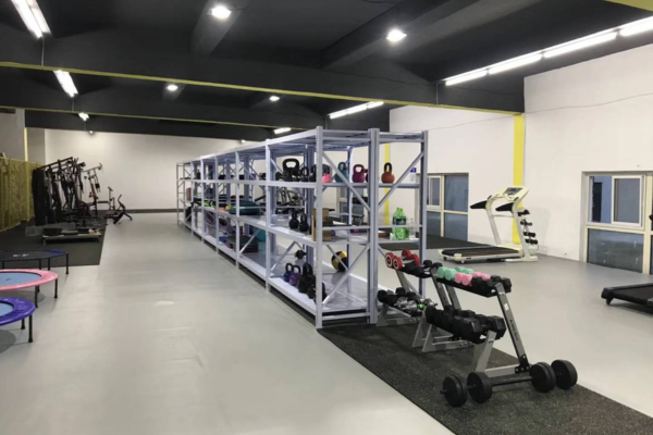 Full view of commercial gym dumbbell and kettlebell inventory shelving
