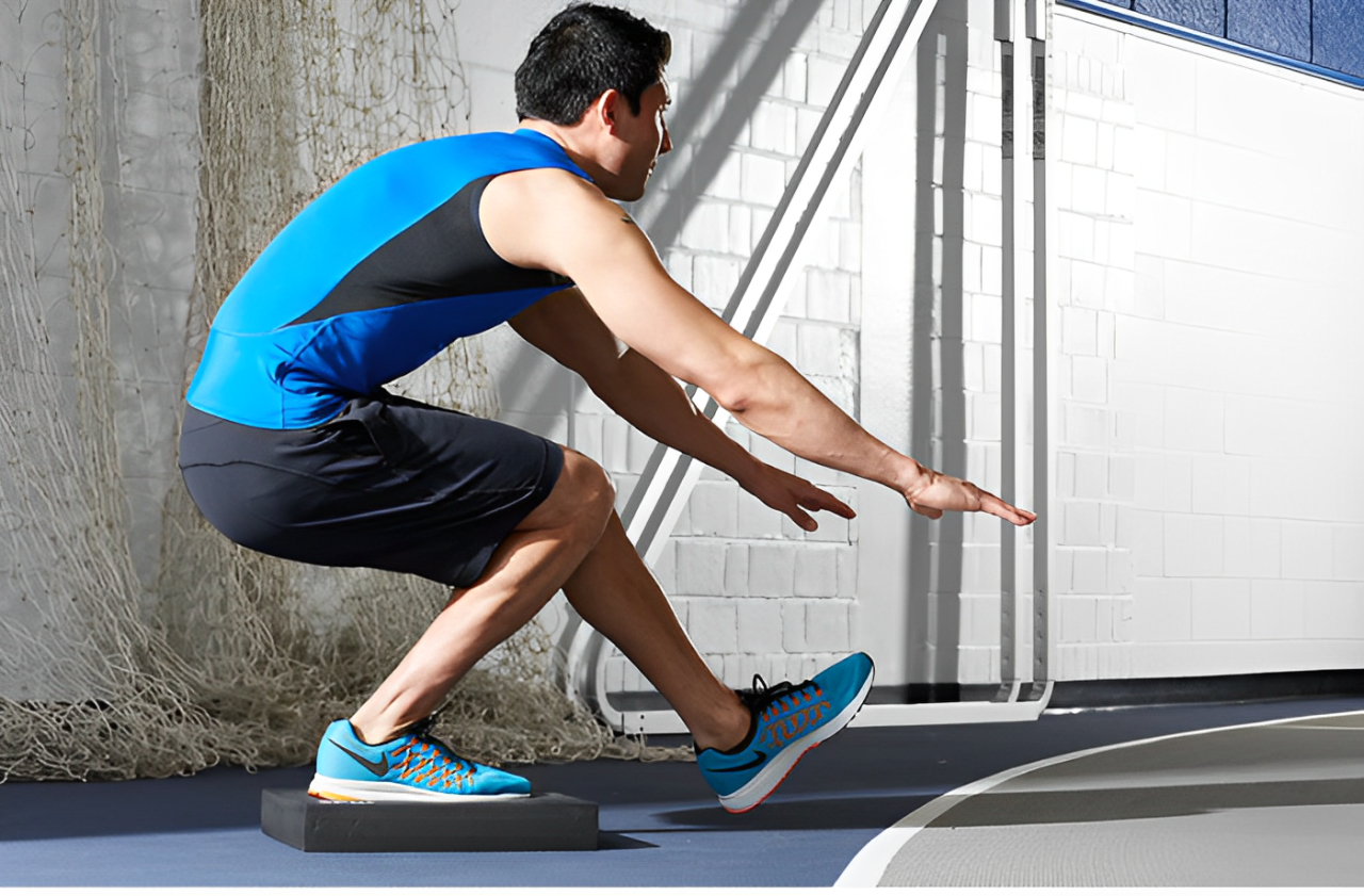 Male athlete performing single-leg squat on black foam balance pad