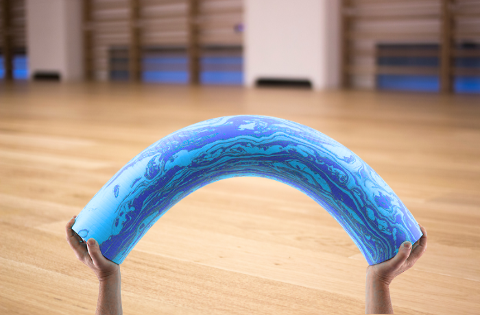 Flexible blue soft foam roller being bent to show material softness