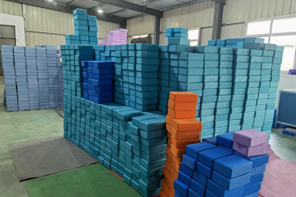 Huge warehouse stacks of blue, purple, and orange yoga blocks awaiting order fulfillment