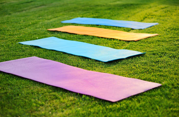 Colorful yoga mats laid on grass for outdoor use