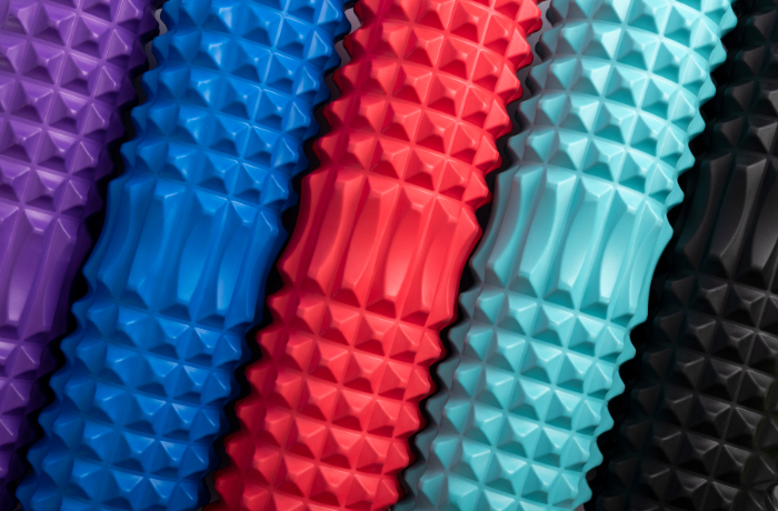 Close-up of textured foam rollers in vibrant colors including purple, blue, red, and black