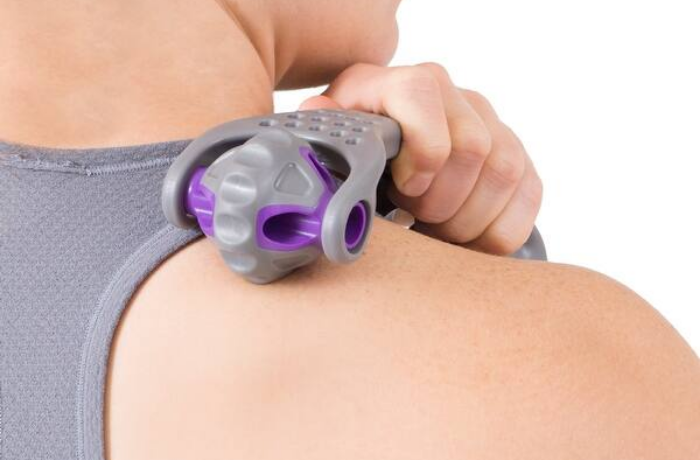 Person using mini massage roller under foot—portable tool for quick muscle relief, blood flow, and daily recovery.
