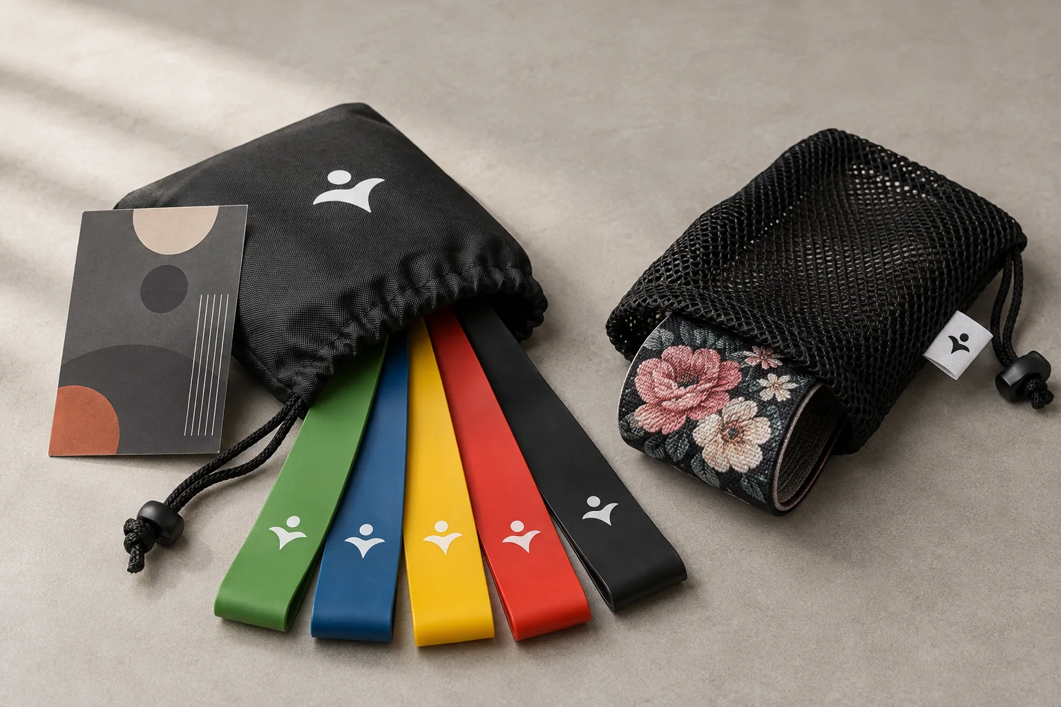 Five-color band set fanned from a black nylon drawstring pouch beside a mesh bag with fabric band