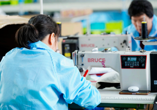 Skilled workers in a modern factory producing yoga and fitness products in bulk at Wellfitsource.